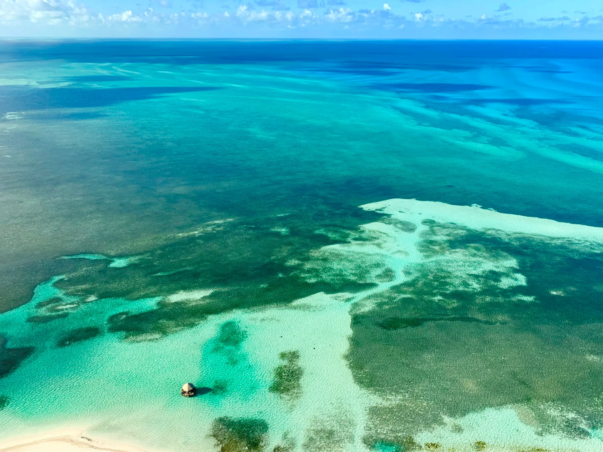 Aerial view of barrier-reef patterns in vivid blue and green water, Andros